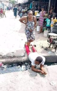 Man Lies On A Gutter For His Pregnant Wife To Pass (Photos)