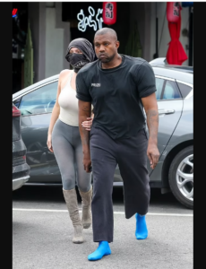 Kanye West shows off bizarre new style as he rocks shoulder pads and blue socks while out with his wife Bianca Censori (photos)